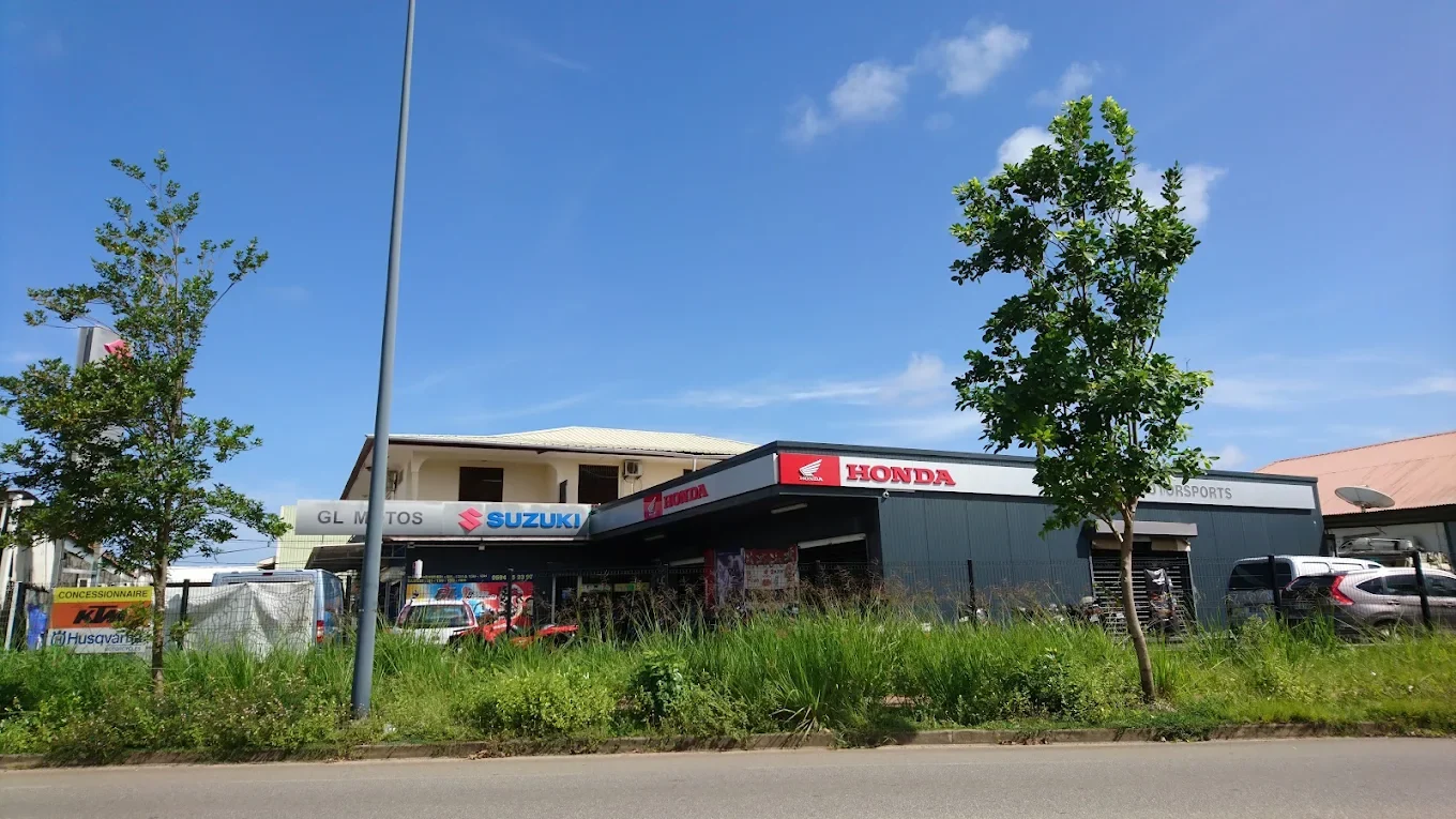 La concession GL Motos vue depuis la route, enseignes Honda et Suzuki